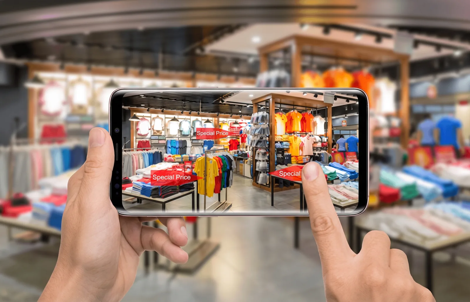 Cliente usa o celular para ver ofertas dentro de uma loja de roupas, exemplo de tecnologia integrando o varejo fisico e digital